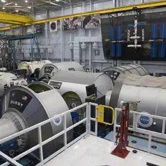 A large room filled with various spacecraft components and equipment, used for testing and training purposes.