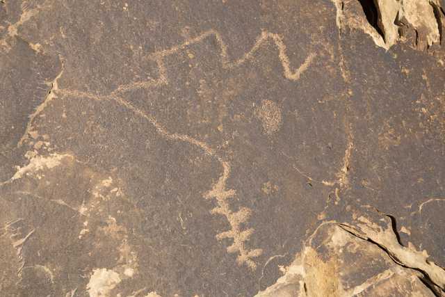An abstract design is carved into a rock surface.