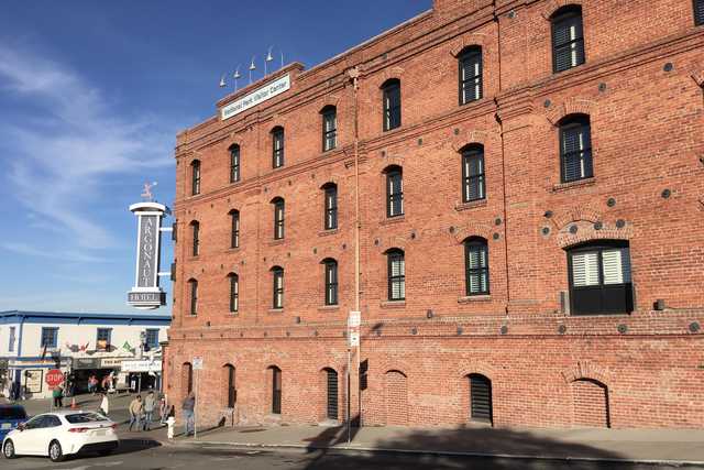 A red brick building with numerous windows is visible on a street corner.