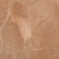 A rock surface with a faded, indistinct figure etched into it.