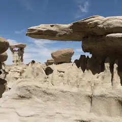 Eroding rock formations create a maze of balanced slabs, spires, and hollowed-out arches in an arid landscape.