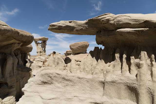 Eroding rock formations create a maze of balanced slabs, spires, and hollowed-out arches in an arid landscape.