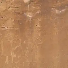 A rock face with faint, carved human figures.