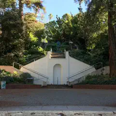 A concrete staircase ascends a hillside bordered by trees.