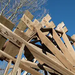 A wooden water wheel seen from below.