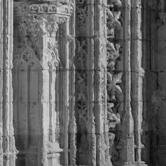 An intricately carved stone church facade features ornate carvings and detailed stonework.