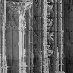 An intricately carved stone church facade features ornate carvings and detailed stonework.